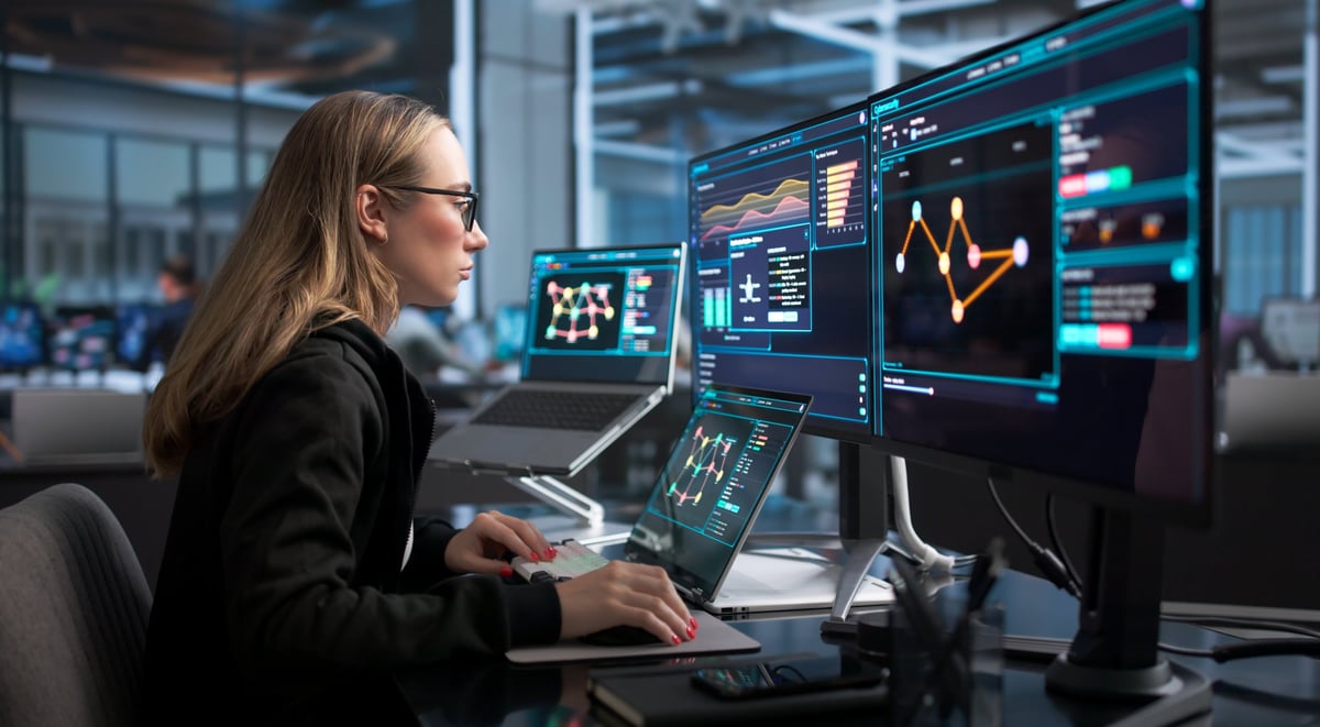 Woman Works On Laptop Monitoring Real-time Network Security Threats.